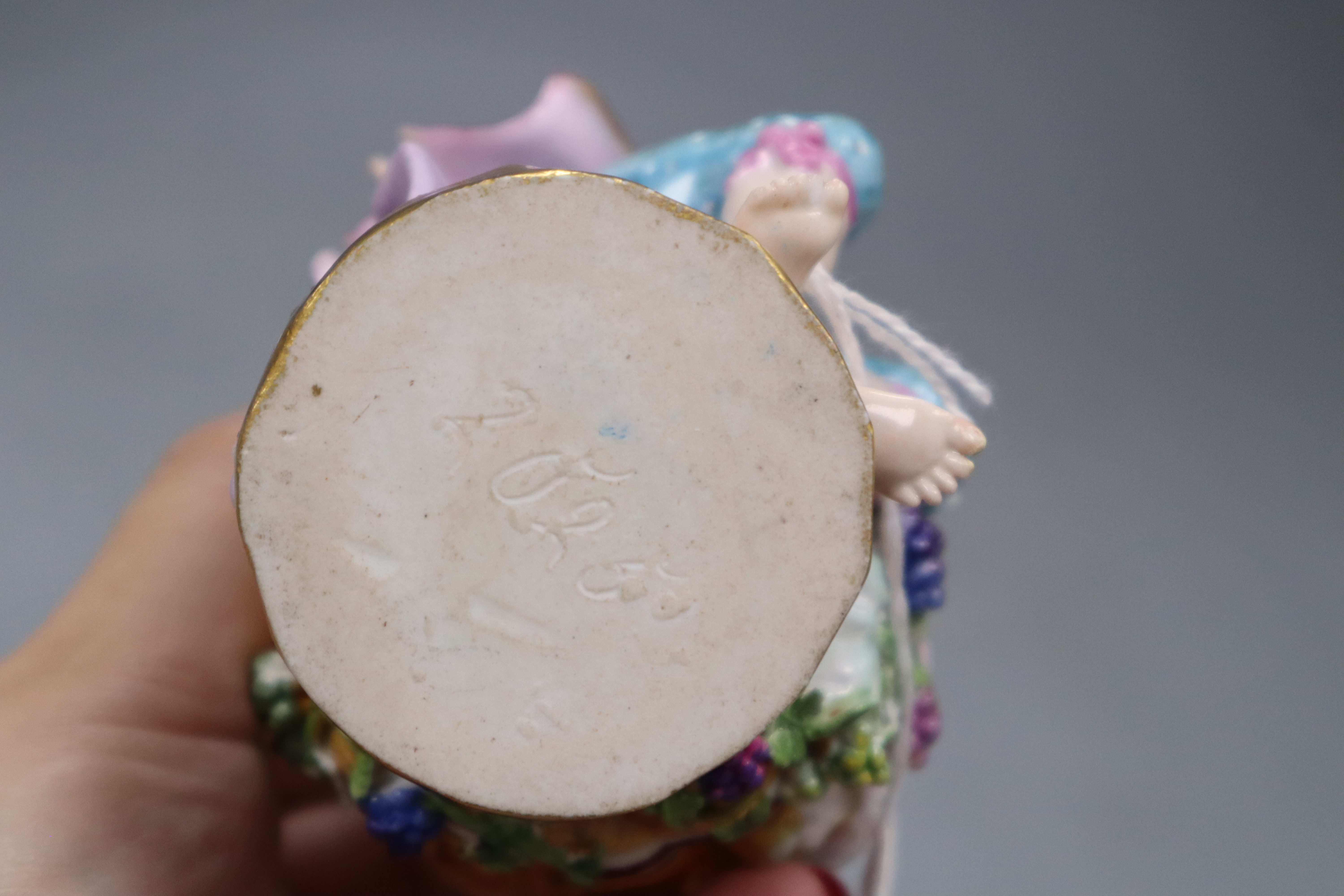 A late Meissen figural salt, modelled as a seated gallant and companion beside a floral encrusted shell